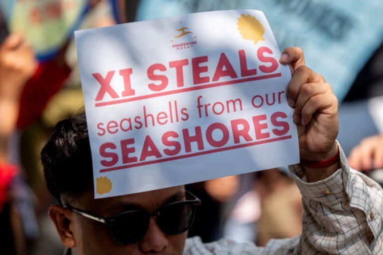 A Filipino activist holds a placard during a protest condemning China's actions during an encounter in the disputed waters of the South China Sea, outside of the Chinese Consulate in Makati City, Metro Manila, Philippines, April 9, 2024. REUTERS/Lisa Marie David