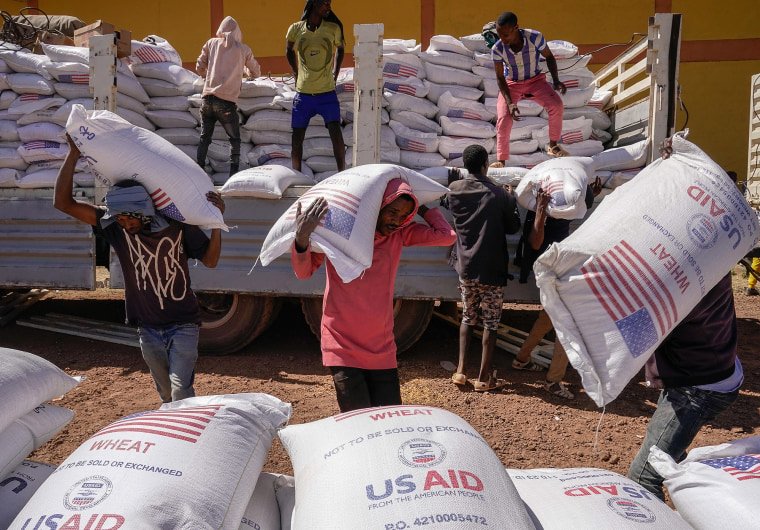 Volunteers at a displacement camp unload an aid delivery from USAID on Dec. 17, 2021 in Bahir Dar, Ethiopia.