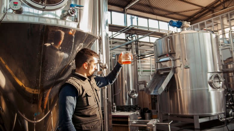 person testing beer with brewery equipment