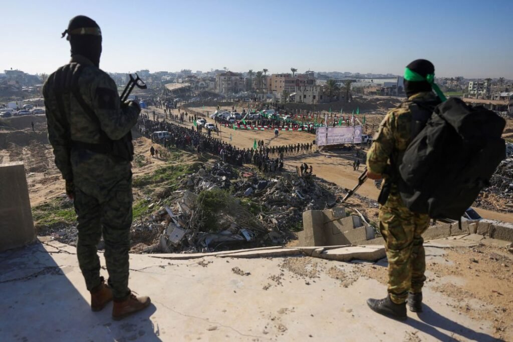 Hamas militants monitor the area before handing Israeli hostages over to a Red Cross team in Khan Yunis on Saturday.