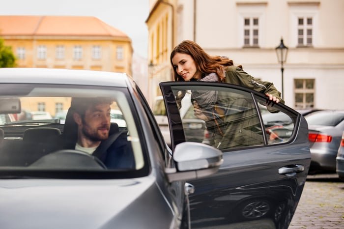 A person getting into the back seat of a car.