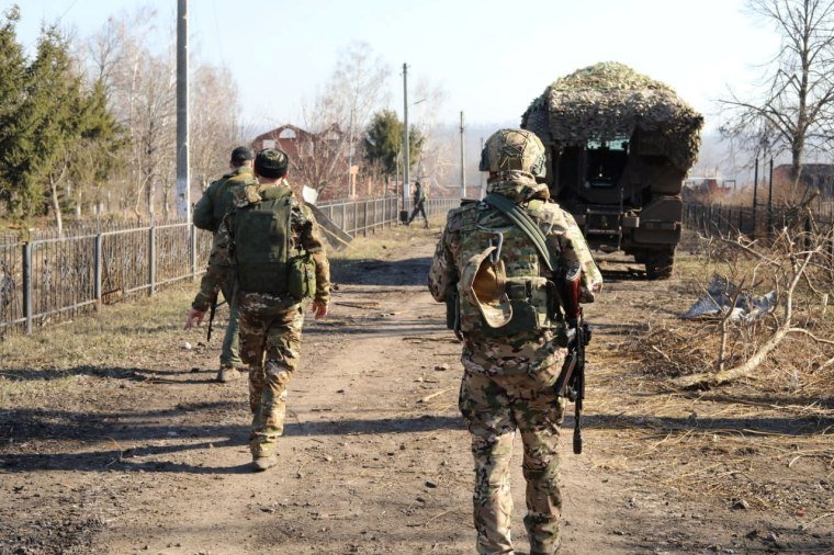 Russian service members walk along a street in Kursk region ukraine russia conflict