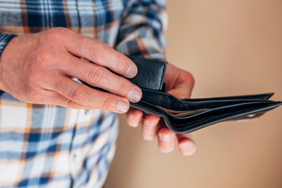 Person opening an empty black wallet