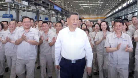 Chinese leader Xi Jinping visits a ballbearing factory in Luoyang, China on May 20 2025. He is surrounded by the plant’s staff who are clapping.