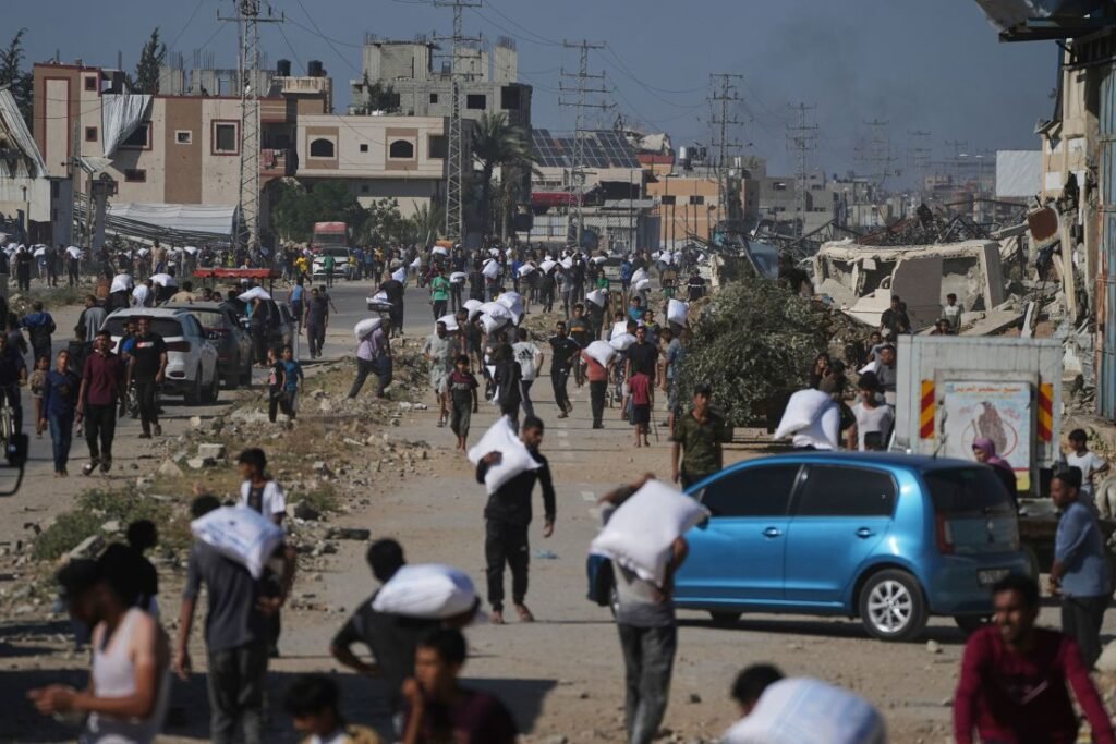 Palestinians carry bags of flour after storming a UN World Food Program warehouse in Central Gaza on May 28.