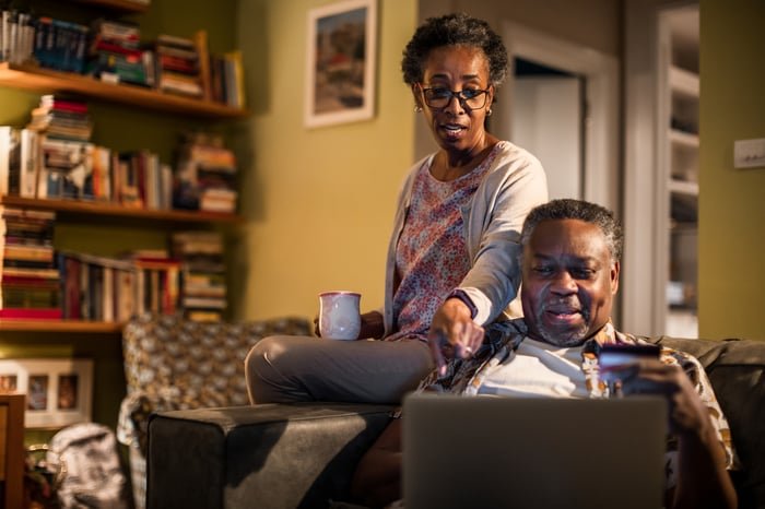 Two adults looking at a laptop.