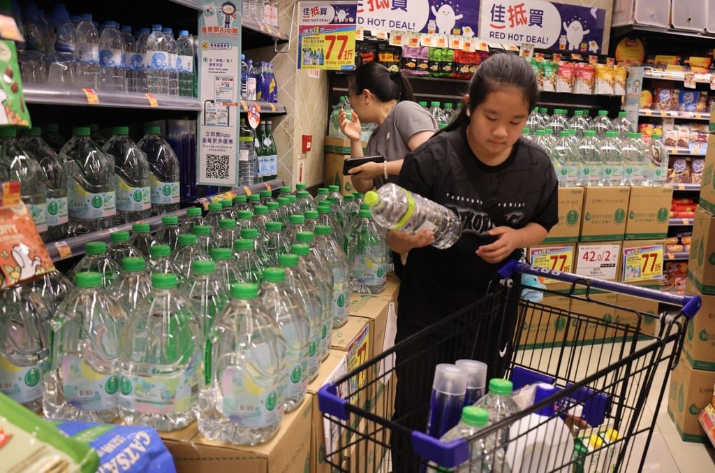 A resident at Queens Hill Estate in Fanling buys bottled water following concerns over water safety. Photo: Nora Tam