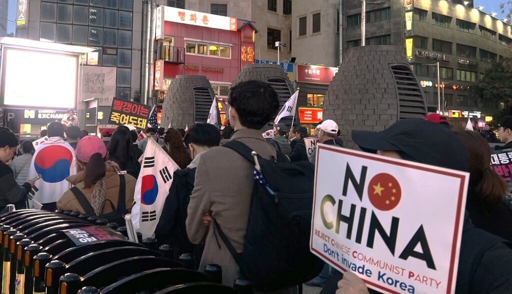 Protesters hold South Korean flags and a placard with anti-China slogans during a rally in front of the Chinese Embassy in Jung District, central Seoul, in March. [YONHAP]