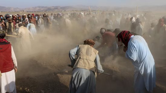 Afghan mourners and relatives of victims cover the graves with soil during a mass burial ceremony for nine children and one woman who were killed by a Pakistan air strike, in the Gurbuz district of Khost Province on November 25, 2025. (AFP)