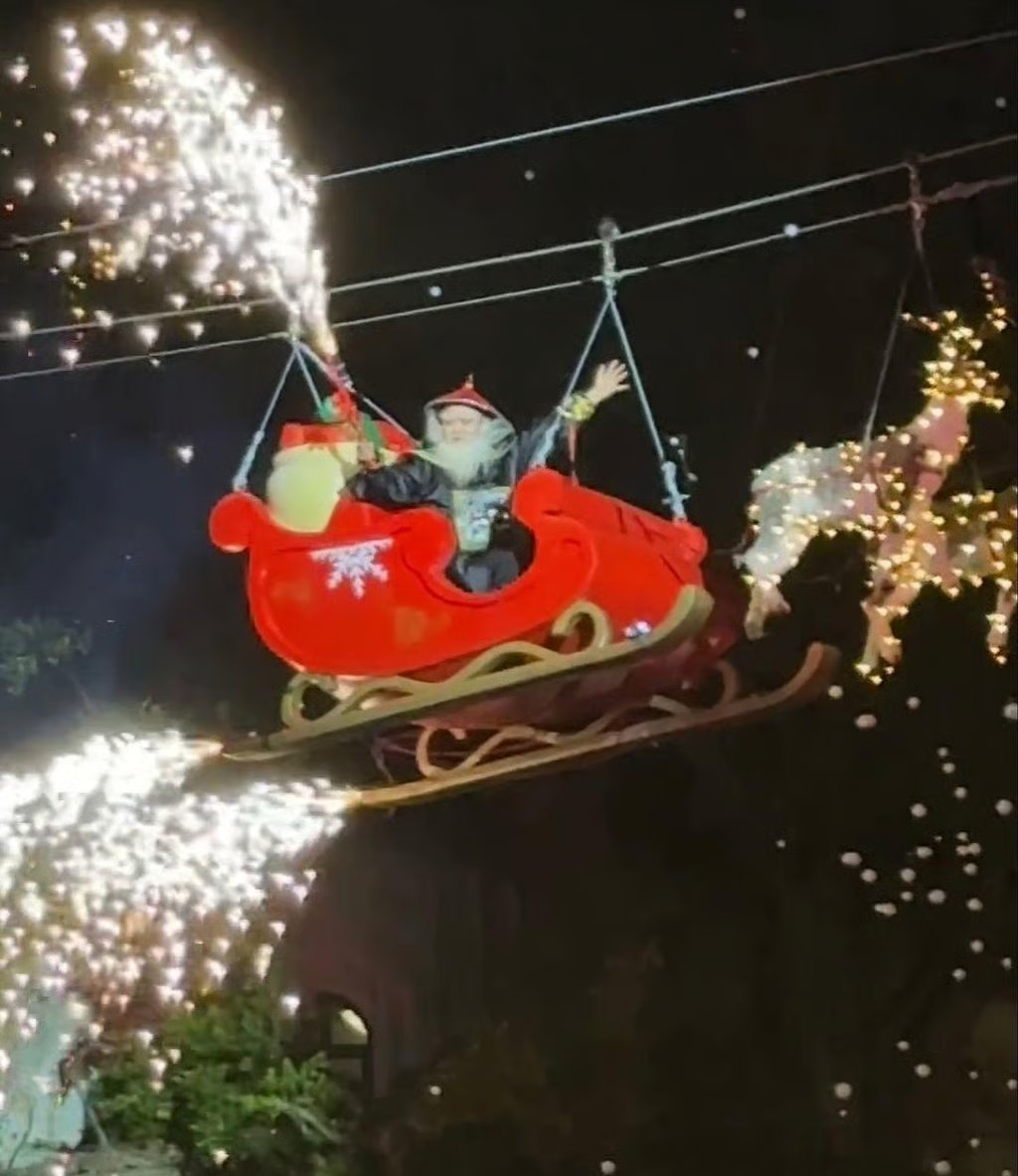 At a southern China tourist resort, a festive event featured Oboi, played by an actor, sitting in a sleigh pulled by two wooden reindeer, soaring through the air, illuminated by fireworks sticks. Photo: ifeng