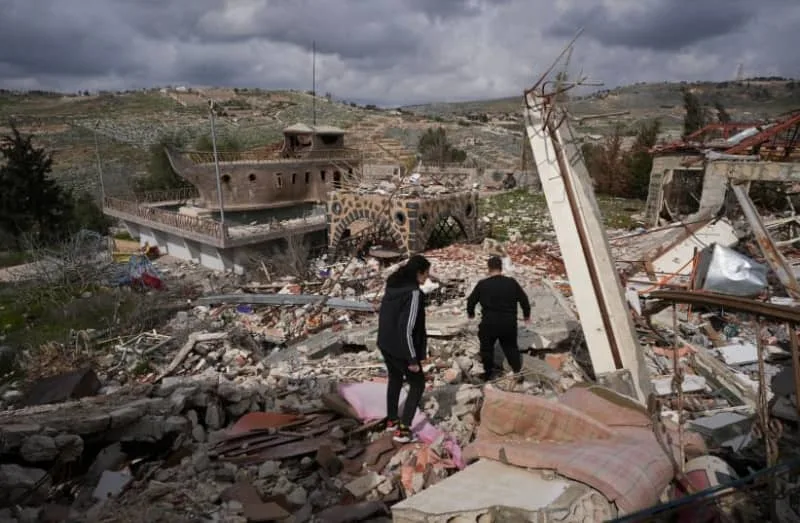 People walk at a damaged site in Mays al-Jabal, near the border with Israel, southern Lebanon, February 19, 2025 (credit: REUTERS/Mohammed Yassin)