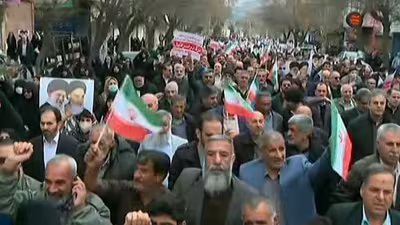 This grab taken from handout video footage released by Iran Press on January 9, 2026, shows pro-government demonstrators chanting slogans as they march along a main street in Khorramabad, western Iran. (AFP)