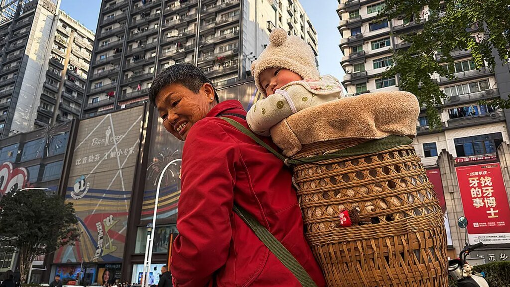 Baby in traditional Chinese bamboo basket on grandmother's back