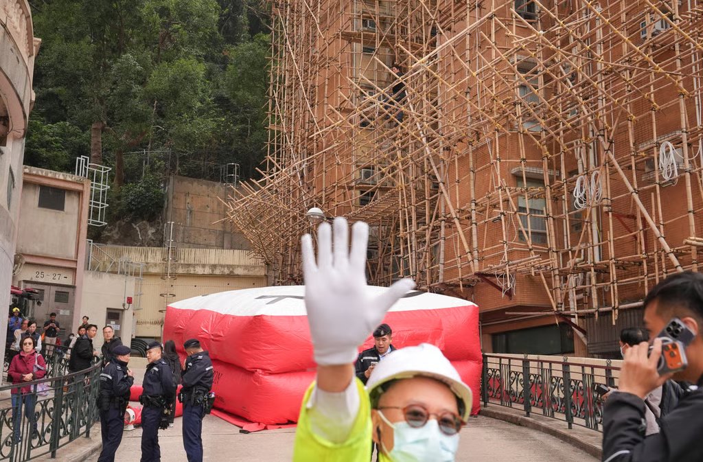 Fire Services Department officers set up a rescue cushion beneath the scaffolding at Baguio Villa on Wednesday. Photo: Elson Li