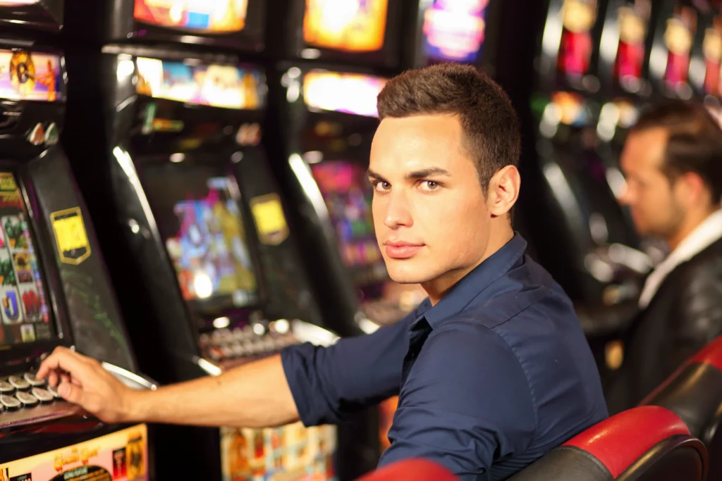 Person at slot machine at casino.