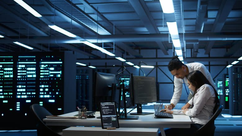Two IT workers in a supercomputer server room