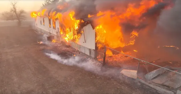 Flames consume a home in western Oklahoma on Feb. 17, 2026 after the Range Road Fire exploded in size.