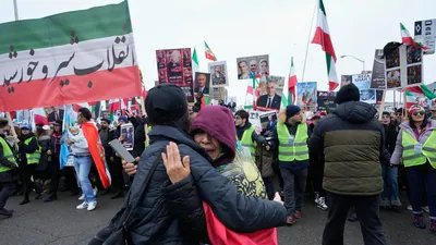 A woman comforts one of the protesters as the supporters of Iran's exiled Crown Prince Reza Pahlavi attend a demonstration in Toronto, Saturday, Feb. 14, 2026. (AP Photo/Kamran Jebreili) (AP)
