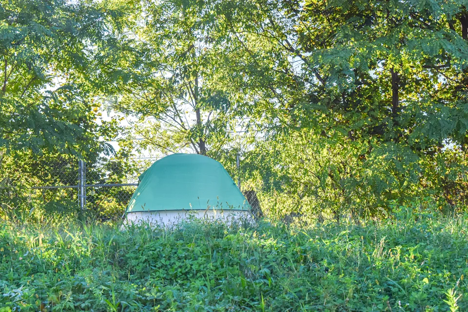 A tent is visible right off Route 10 in Providence in early October 2025. (Photo by Christopher Shea/Rhode Island Current)
