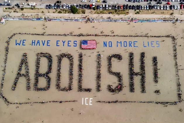 Protesters form a human banner on Ocean Beach in San Francisco in protest of ICE on Saturday.