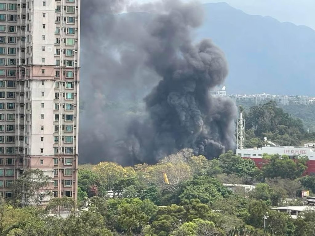 Thick black smoke rises high into the sky above the Tai Po site. Photo: Handout