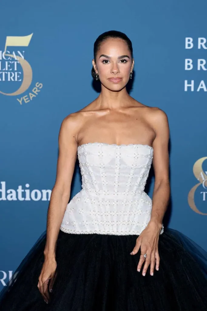 Person in strapless gown with beaded bodice and tulle skirt poses at an event; elegant hairstyle and minimal jewelry