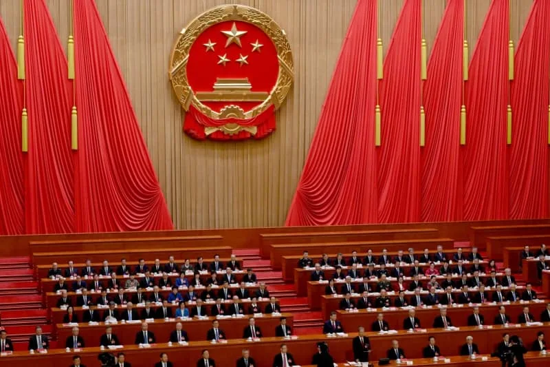 Deputies sit in the plenary hall of the Great Hall of the People during the closing ceremony of the National People's Congress. Johannes Neudecker/dpa