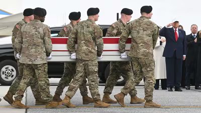 US President Donald Trump salutes as members of a US Army team carry the flagged-drapped transfer case containing the remains of US soldier Sgt. 1st Class Noah L. Tietjens during a dignified transfer solemn event at Dover Air Force Base, in Dover, Delaware. (AFP)