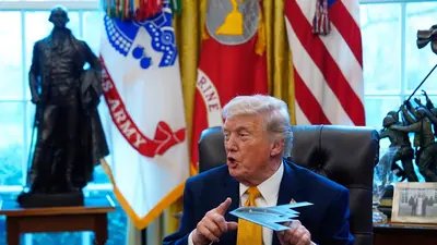 President Donald Trump holds a model of a B-2 stealth bomber as he speaks after signing an executive order in the White House (AP)