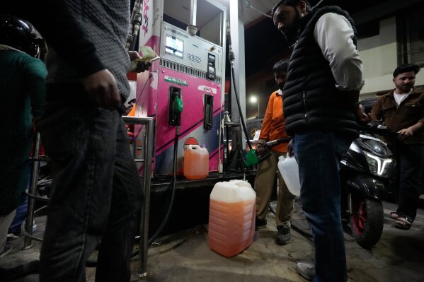 People store fuel in a plastic can at a petrol pump amid fears of a possible shortage due to the US Iran war, in Srinagar, Indian controlled Kashmir, Wednesday, March 25, 2026. (AP Photo/Mukhtar Khan)