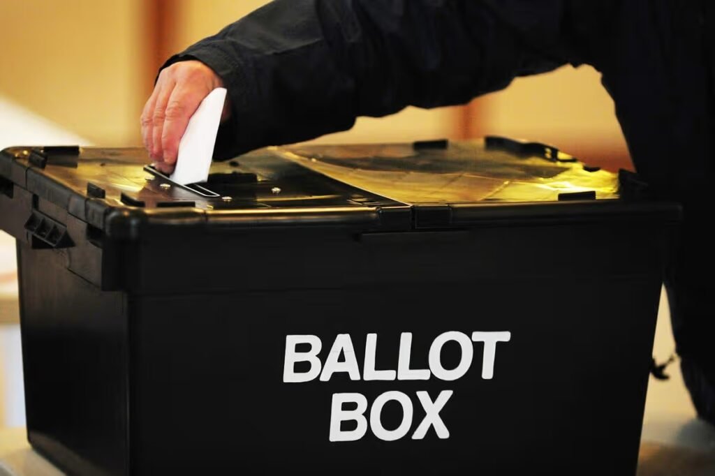 Voter placing a ballot paper in the ballot box at the polling station