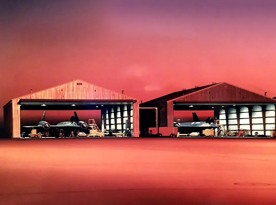 A pair of SR-71 Blackbirds sitting idle in their hangars on the flight line at Beale Air Force Base, California, at dawn. <em>U.S. Air Force</em><br>