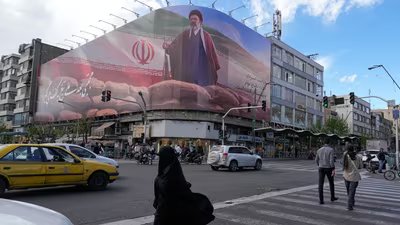 People walk past a billboard that shows a graphic depicting Iran's Supreme Leader Ayatollah Mojtaba Khamenei in downtown Tehran, Iran. (AP)