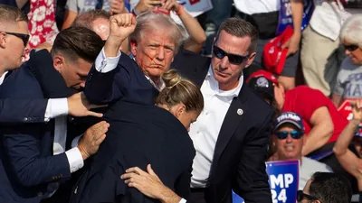 Donald Trump is seen with blood on his face, surrounded by Secret Service agents, as he is taken off the stage at a campaign event at Butler Farm Show Inc. in Butler, Pennsylvania, in 2024. (AFP File)