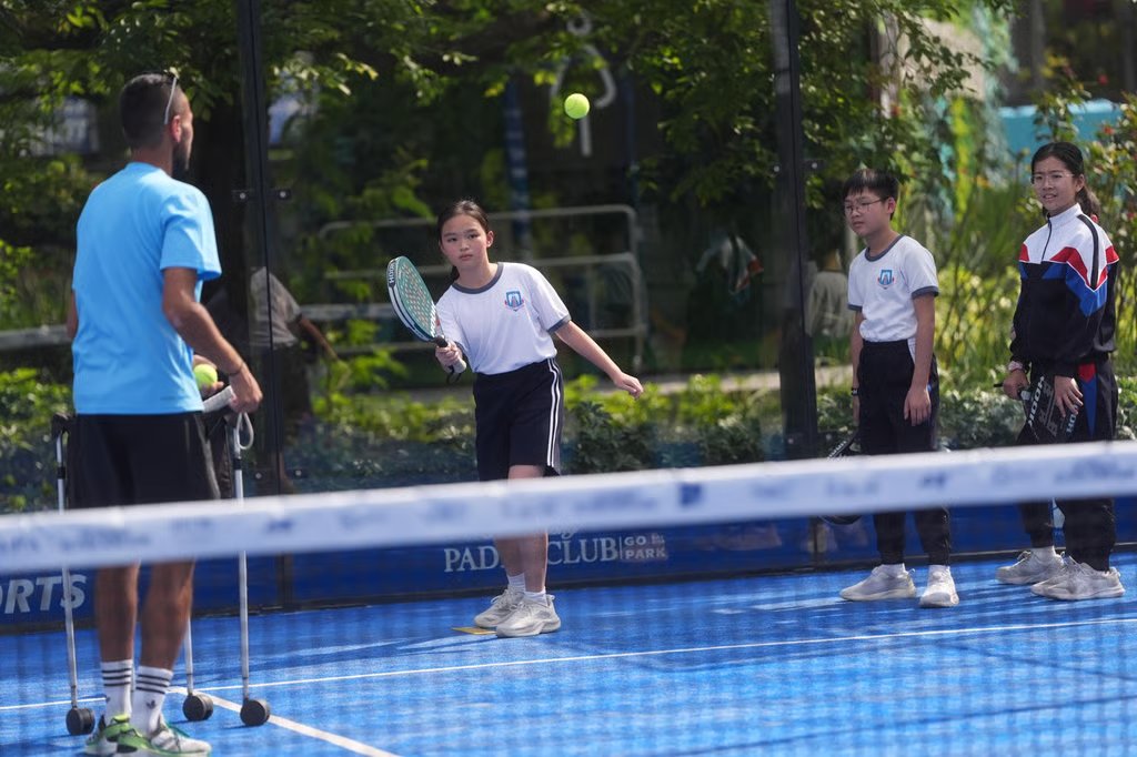 Primary school pupils try padel, a hybrid of tennis and squash, with a coach in Go Park Sai Sha on March 18. Photo: Elson Li