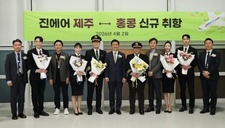 Jin Air CEO Park Byung-ryul, sixth from left, and cabin crew mark the inaugural flight of a new Jeju-Hong Kong route. Courtesy of Jin Air
