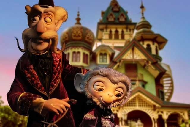 A puppet man with a tall hat stands beside a smiling monkey at the whimsical Hong Kong Disneyland Albert Meet and Greet.