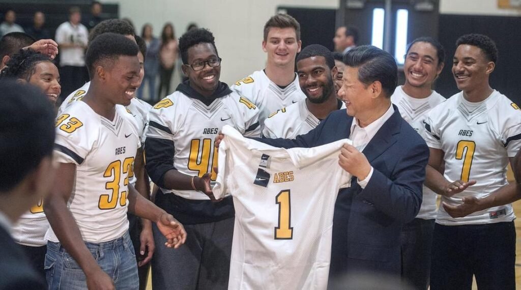Members of the Lincoln football team laugh with Chinese president Xi Jinping after giving him a team jersey to commemorate his visit to Lincoln High on Wednesday, Sept. 23, 2015.