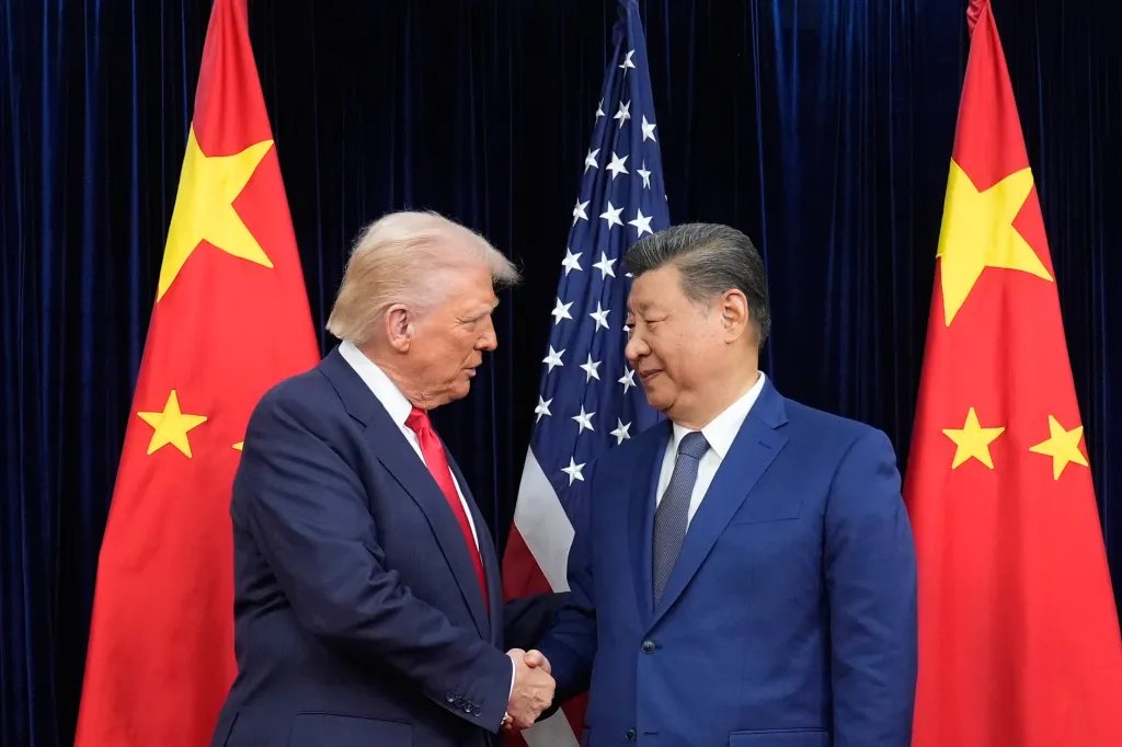Donald Trump and Xi Jinping shaking hands, with the US and Chinese flags behind them.