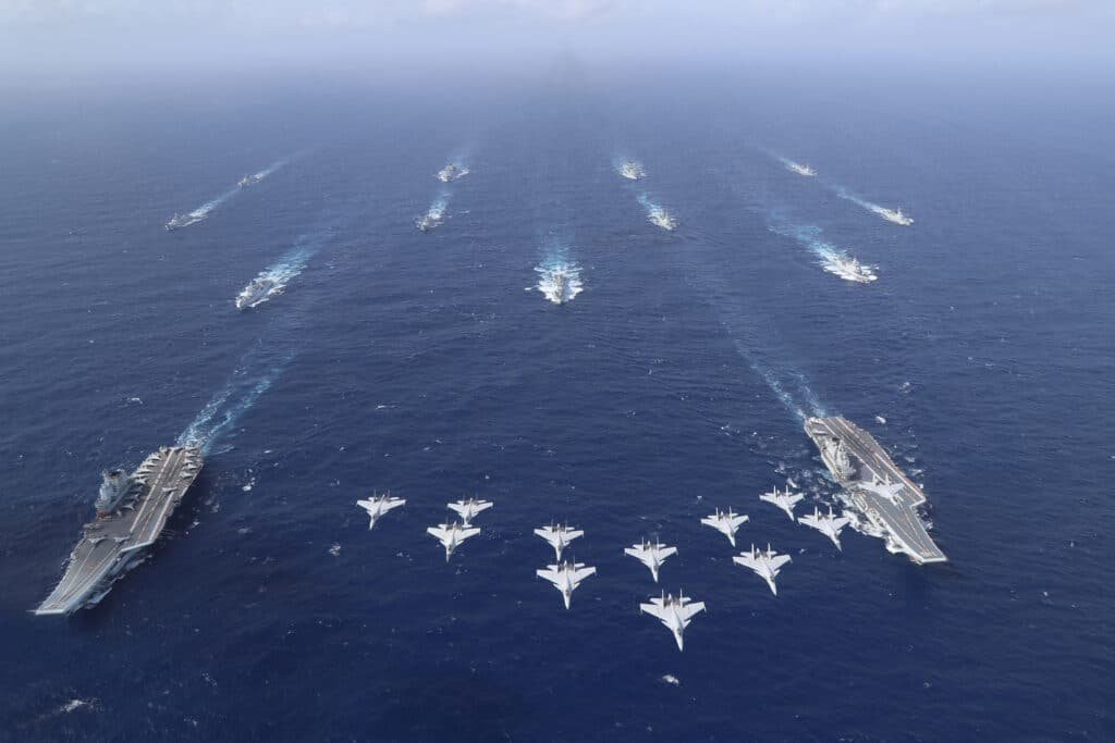 Image showing aircraft flying overhead two aircraft carriers and their escorts.