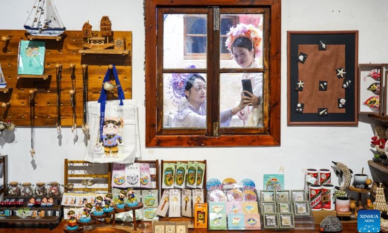 Tourists take photos in Liruo Village, Shitang Town, Wenling City, east China's Zhejiang Province, May 2, 2026. Shitang Town, located in Wenling City of Zhejiang Province, is a traditional fishing port surrounded by the sea on three sides. During this year's May Day holiday, the town hosted a variety of fishing culture activities, drawing tourists from across the country. (Xinhua/Jiang Han)