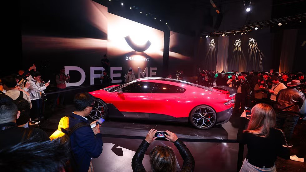 electric sports car showcased at an event with an audience