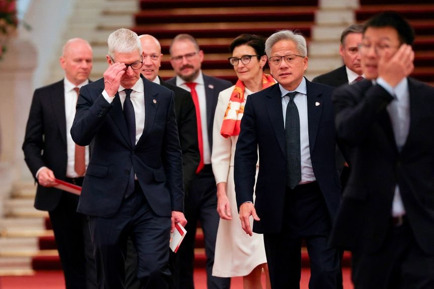 Nvidia CEO Jensen Huang, center right, Apple CEO Tim Cook, center left, and Citi CEO Jane Fraser, rear center, arrive for the meeting between Chinese Premier Li Qiang and US business representatives, at the Great Hall of the People in Beijing, on Thursday.