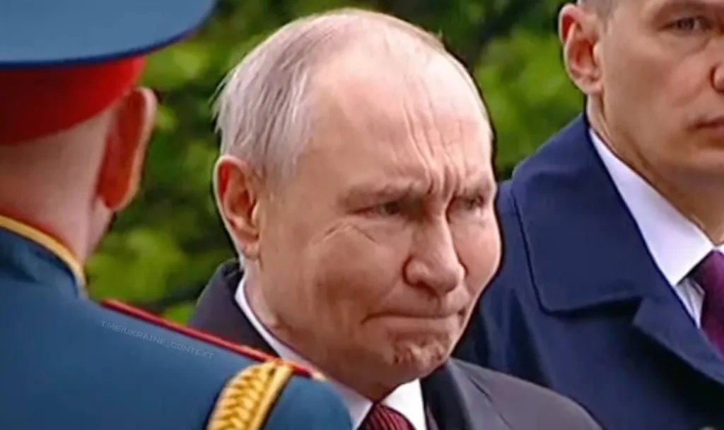 Close-up of Putin's face with a worried expression, wearing a suit and tie, with parts of two other people visible on either side.